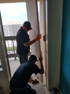 Two technicians installing a new door.